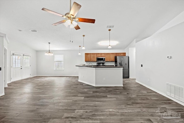 kitchen featuring hanging light fixtures, appliances with stainless steel finishes, dark hardwood / wood-style floors, and lofted ceiling