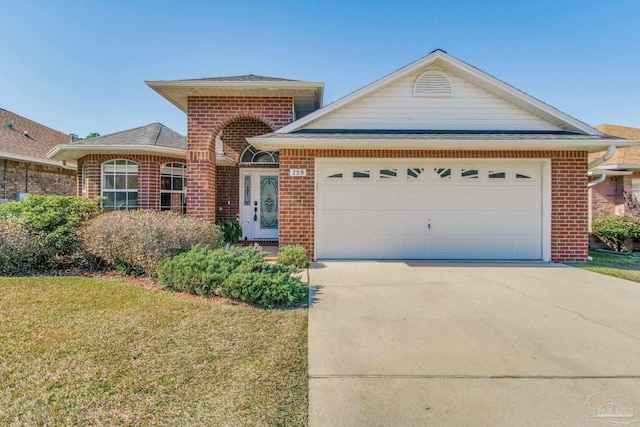 view of front of home with brick siding, driveway, a front yard, and a garage