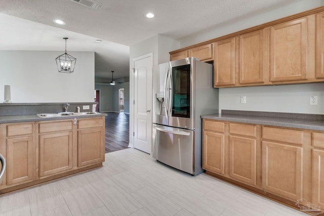 kitchen with visible vents, stainless steel fridge with ice dispenser, a sink, decorative light fixtures, and ceiling fan with notable chandelier