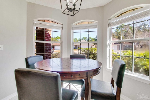 dining room with plenty of natural light, baseboards, and an inviting chandelier