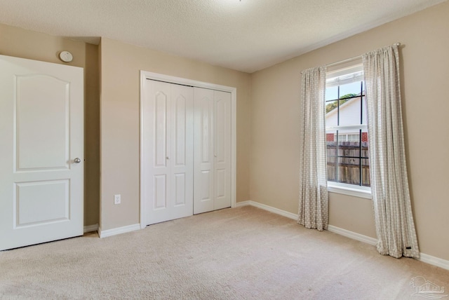 unfurnished bedroom featuring a closet, baseboards, carpet, and a textured ceiling