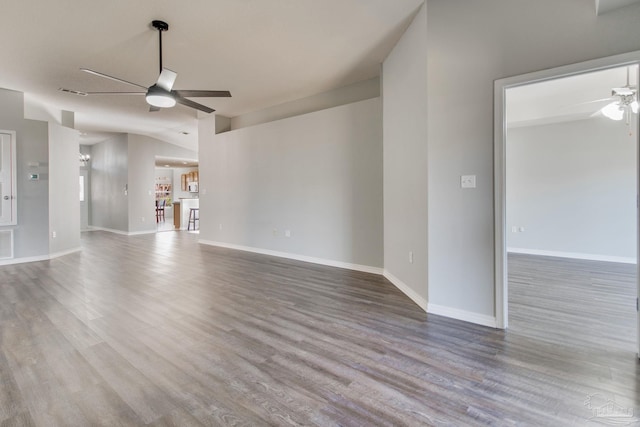 unfurnished living room with baseboards, wood finished floors, and a ceiling fan