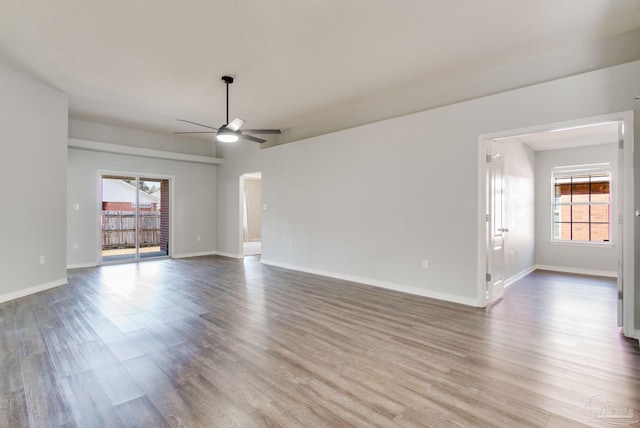 unfurnished room with a healthy amount of sunlight, wood finished floors, and a ceiling fan