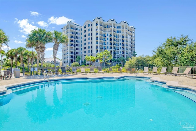 pool with a patio area and fence