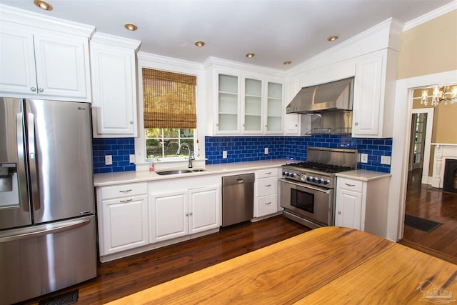 905 N Barcelona St, Pensacola, FL 32501 - kitchen featuring stainless steel appliances, a sink, wall chimney range hood, white cabinets, and ornamental molding