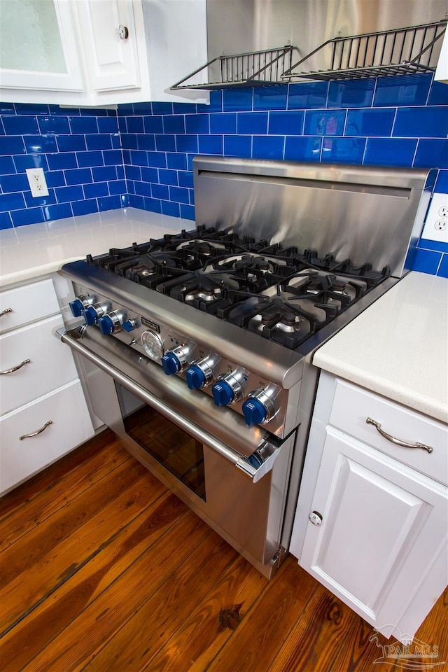 905 N Barcelona St, Pensacola, FL 32501 - kitchen view of stainless steel stove, backsplash, dark wood-type flooring, white cabinetry, and light countertops