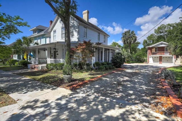 905 N Barcelona St, Pensacola, FL 32501 - view of side of property featuring a porch, driveway, a chimney, and an attached garage