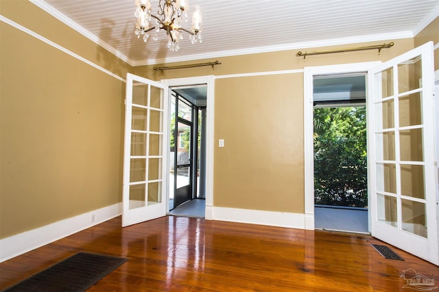 905 N Barcelona St, Pensacola, FL 32501 - spare room with crown molding, baseboards, a chandelier, wood-type flooring, and french doors