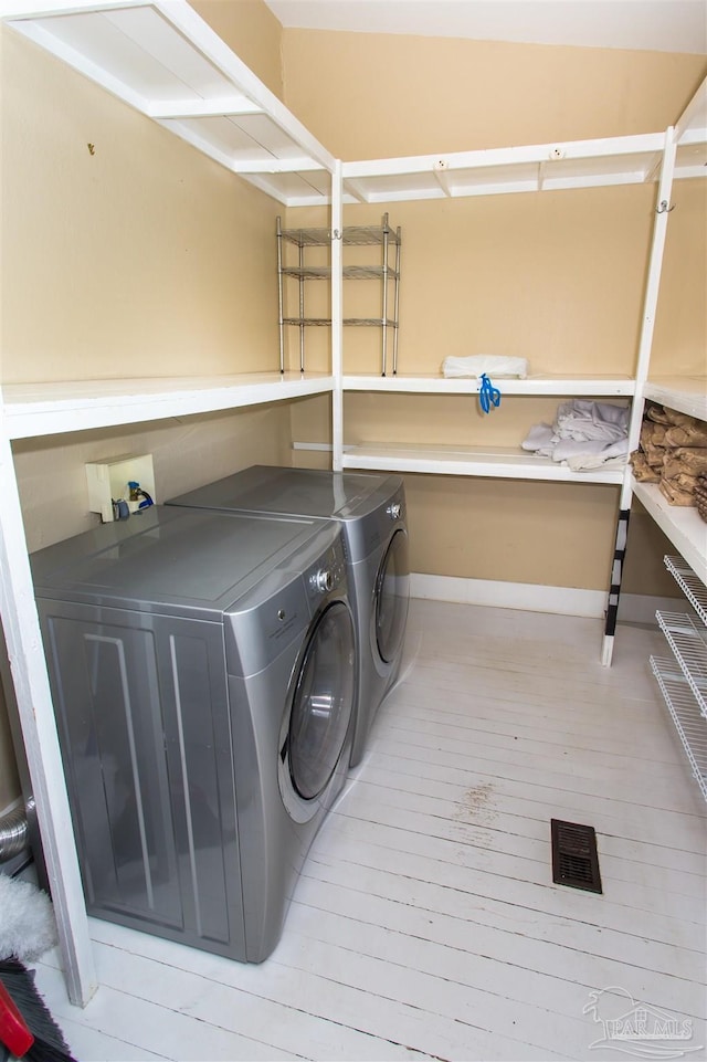 905 N Barcelona St, Pensacola, FL 32501 - washroom with washing machine and clothes dryer, light wood-style floors, and baseboards