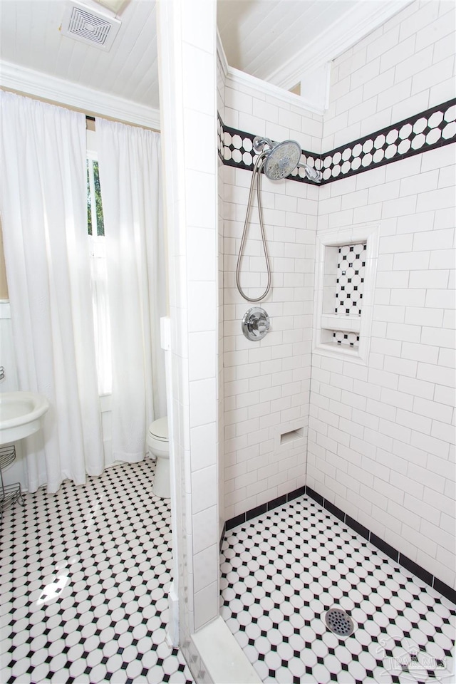 905 N Barcelona St, Pensacola, FL 32501 - full bathroom with tile walls, a tile shower, tile patterned flooring, and toilet