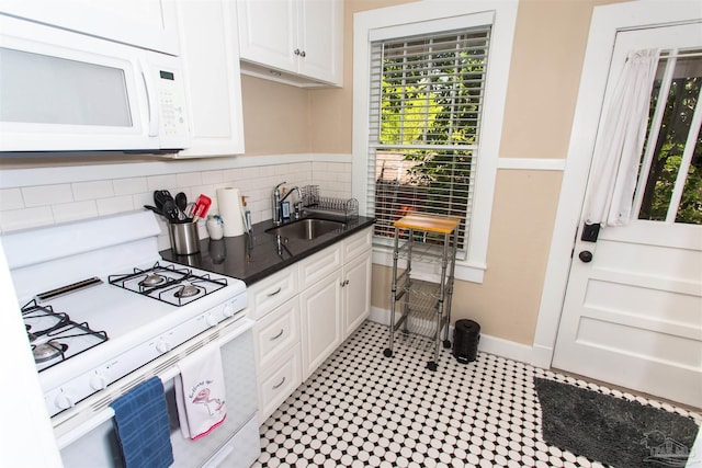 905 N Barcelona St, Pensacola, FL 32501 - kitchen featuring white appliances, a sink, white cabinets, decorative backsplash, and baseboards