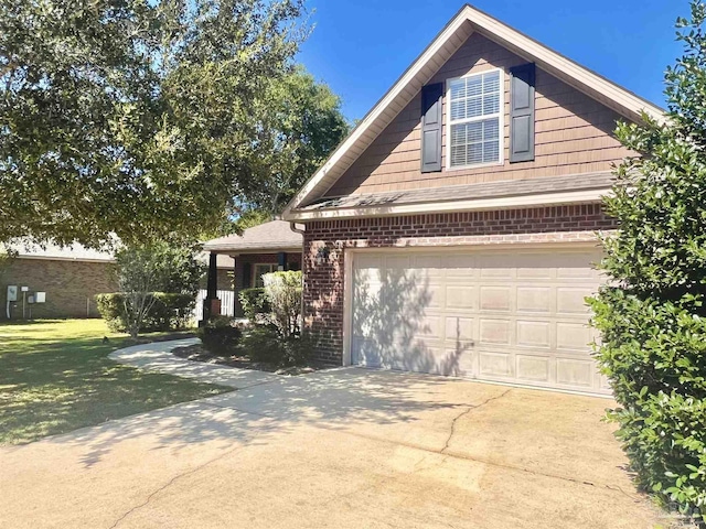 view of front of house with concrete driveway, a front yard, brick siding, and an attached garage