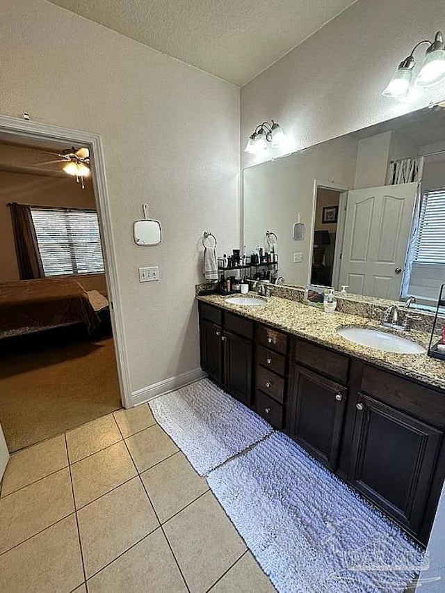 bathroom with tile patterned flooring, a textured ceiling, vanity, and ceiling fan