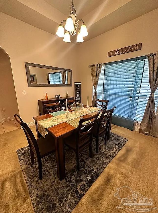 dining area featuring a chandelier and carpet