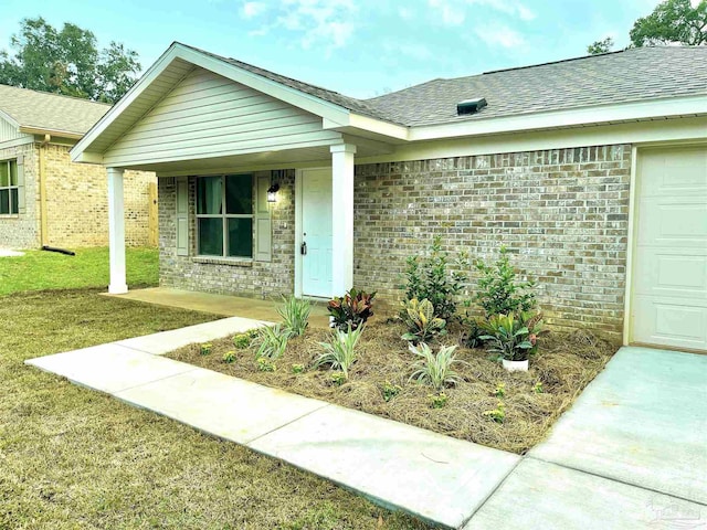 property entrance with a lawn and a garage