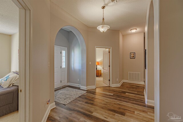 entryway featuring wood-type flooring and a textured ceiling