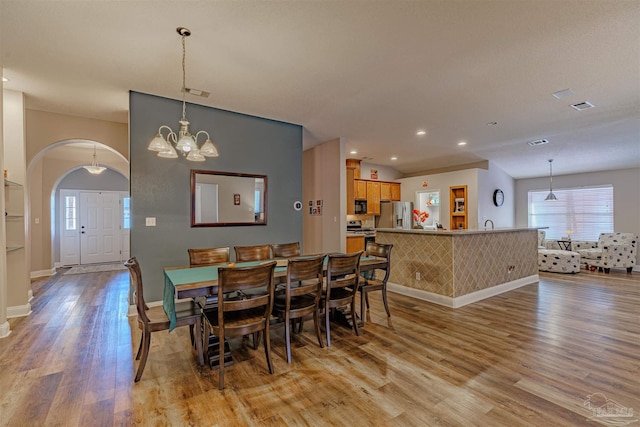 dining area with a chandelier and light wood-type flooring