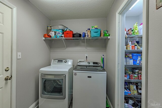 washroom featuring a textured ceiling and washing machine and clothes dryer