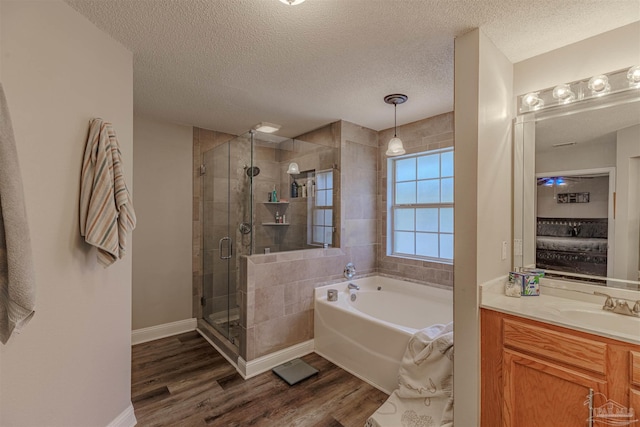 bathroom with hardwood / wood-style flooring, vanity, a textured ceiling, and independent shower and bath