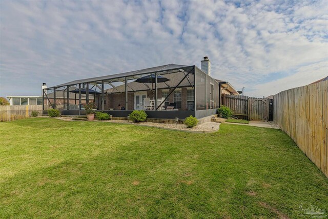 back of property featuring a lanai and a lawn