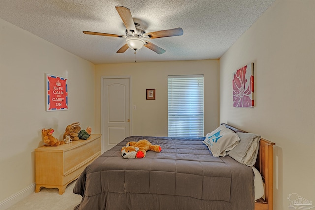 carpeted bedroom with ceiling fan and a textured ceiling