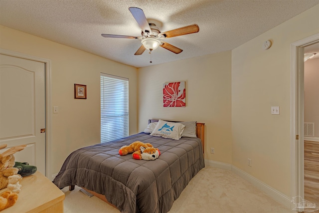 carpeted bedroom featuring a textured ceiling and ceiling fan