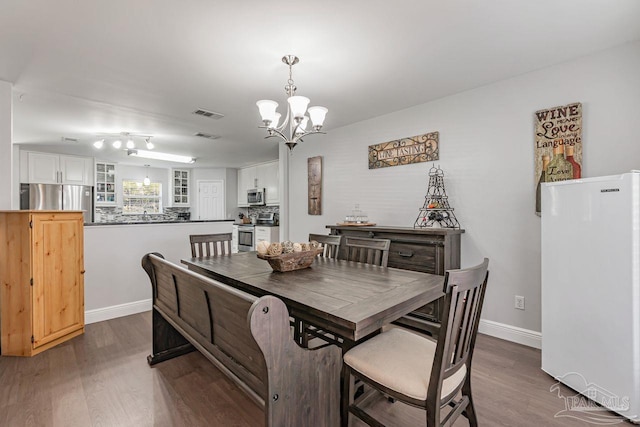 dining area featuring an inviting chandelier and dark hardwood / wood-style floors