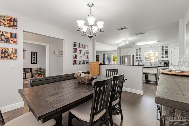 dining area featuring sink, dark hardwood / wood-style flooring, and a chandelier