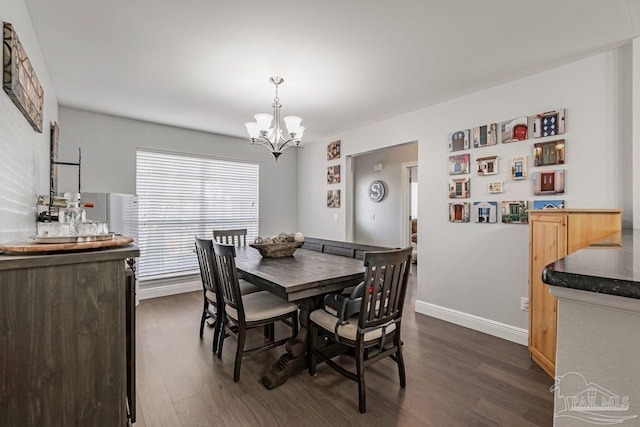 dining area with dark wood-type flooring and a chandelier