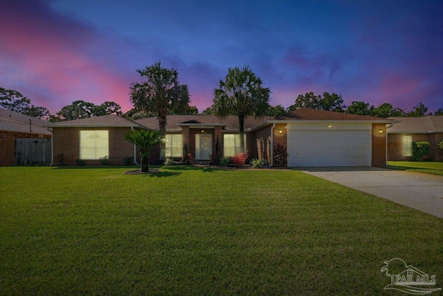 single story home featuring a lawn and a garage