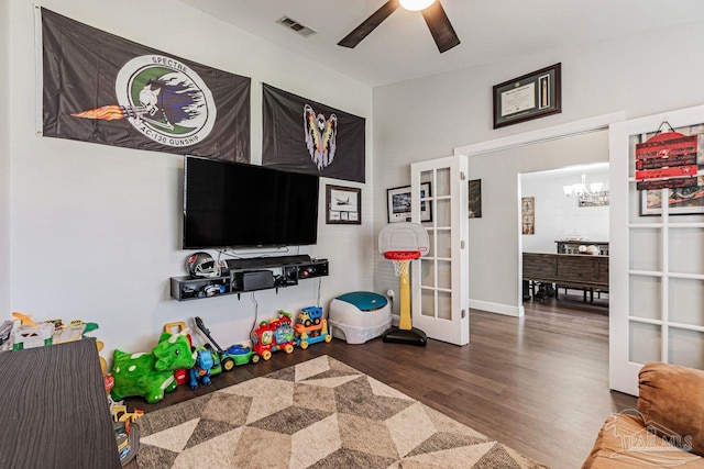 rec room featuring hardwood / wood-style floors, ceiling fan with notable chandelier, and french doors