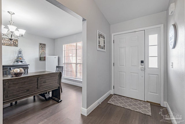 foyer entrance with dark hardwood / wood-style flooring and a chandelier