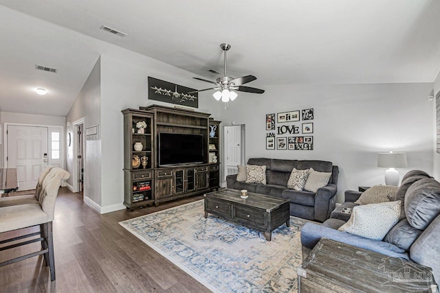 living room with dark hardwood / wood-style flooring, ceiling fan, and vaulted ceiling