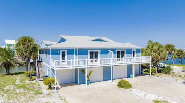 view of front of home with a water view, a garage, and a balcony