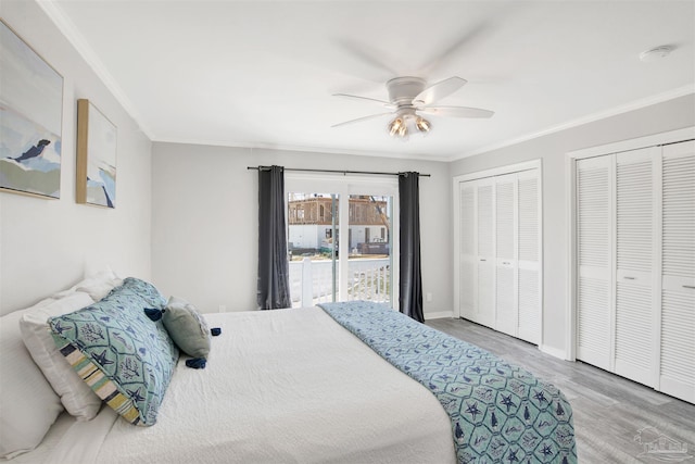 bedroom with ceiling fan, light hardwood / wood-style floors, ornamental molding, and two closets