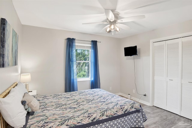 bedroom featuring ceiling fan, light wood-type flooring, and a closet