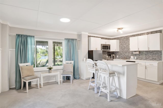 kitchen with a center island, stainless steel appliances, and white cabinetry