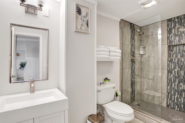 bathroom featuring vanity, toilet, and tiled shower