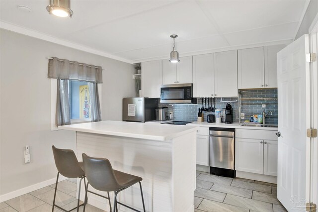 kitchen with pendant lighting, backsplash, white cabinets, sink, and stainless steel appliances