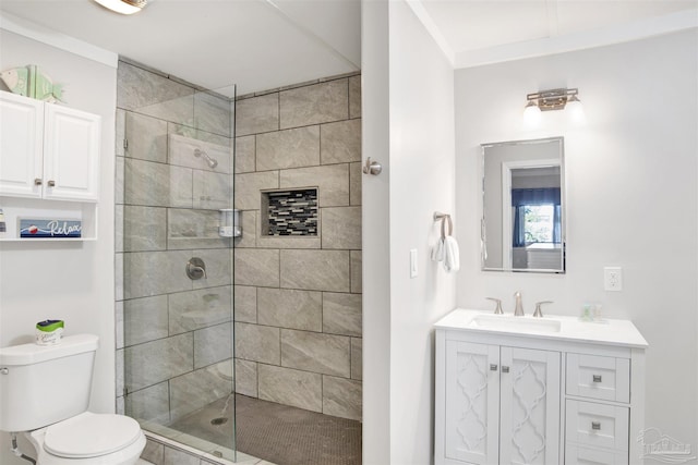 bathroom with tiled shower, vanity, toilet, and crown molding