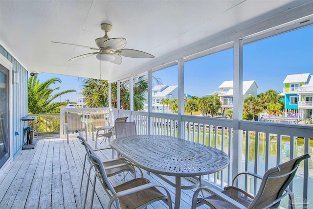 sunroom / solarium with ceiling fan, a water view, and a wealth of natural light