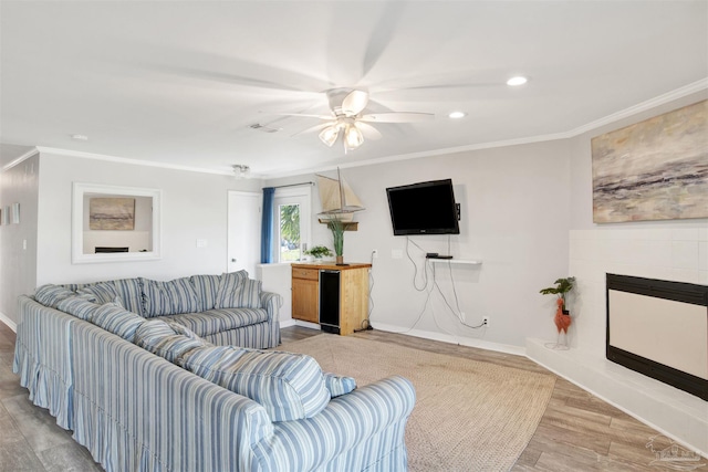 living room featuring ceiling fan, ornamental molding, and hardwood / wood-style flooring