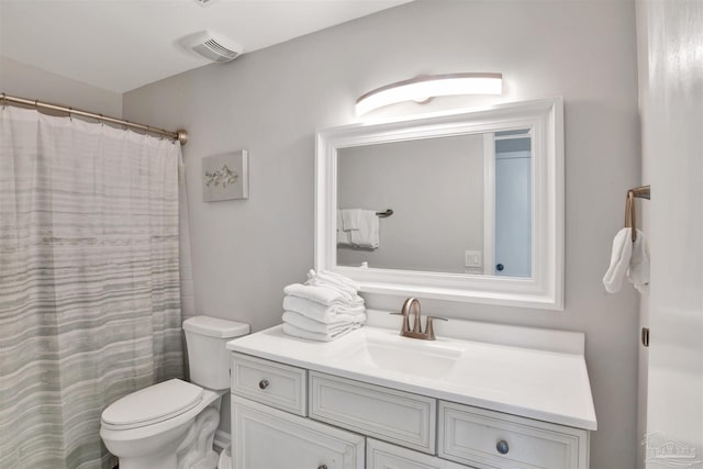 bathroom featuring walk in shower, vanity, and toilet