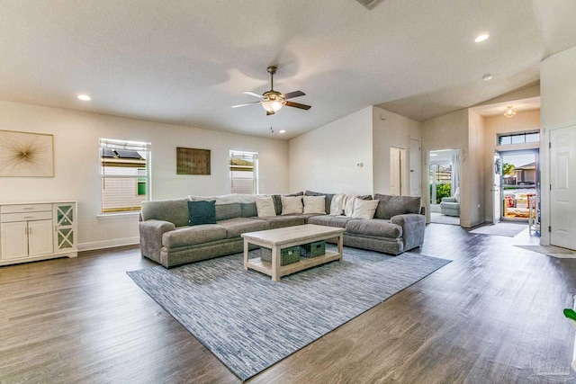 living room with dark wood-type flooring, vaulted ceiling, and a wealth of natural light