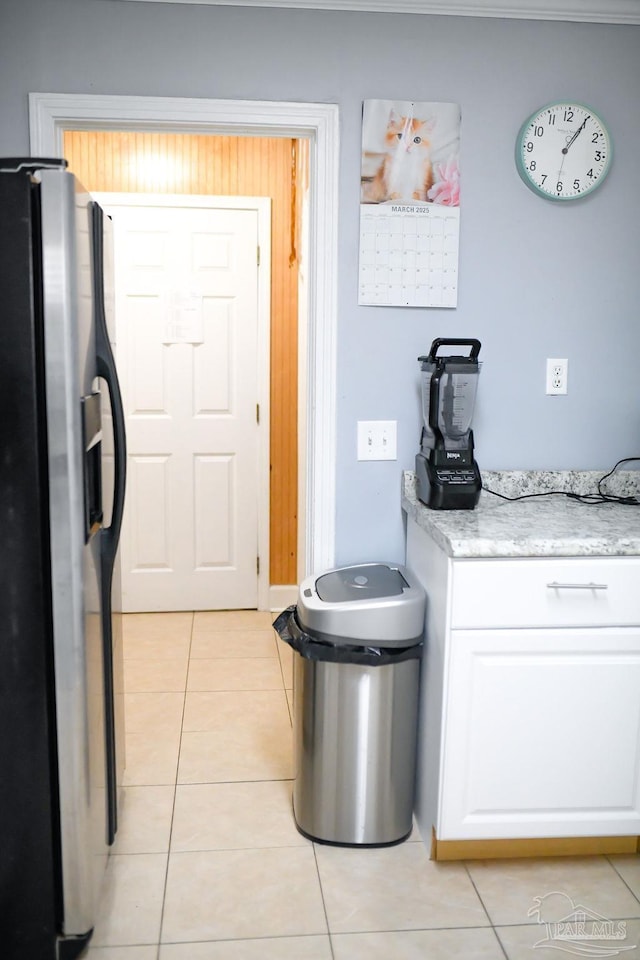 kitchen with white cabinets, refrigerator with ice dispenser, and light tile patterned floors