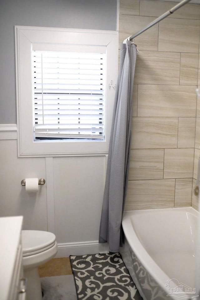 full bathroom with toilet and shower / bath combo with shower curtain