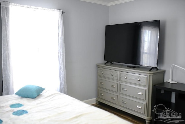 bedroom featuring baseboards, multiple windows, and crown molding