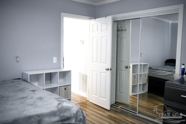 bedroom featuring a closet, visible vents, and wood finished floors