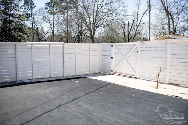 view of gate featuring a patio and a fenced backyard