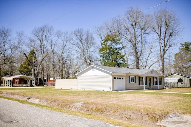 view of front facade with a front lawn, a garage, and fence